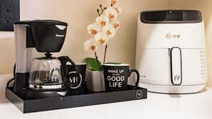 Une machine à café, une tasse et une fleur sur un plateau.
