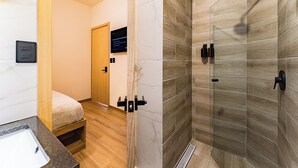 A modern bathroom with a shower, a sink, and a toilet. - Private suites in remodeled old house in Roma Norte (Mexico)