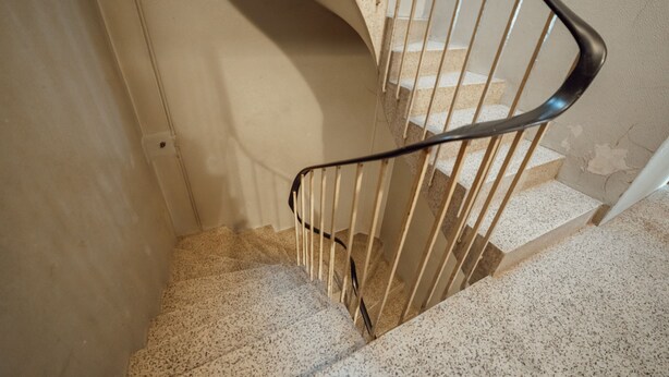 Eine Treppe mit Metallhandlauf und Teppichboden.