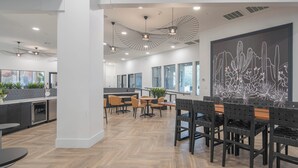 Ein modernes Interieur mit Essbereich, Küche und großen Fenstern.