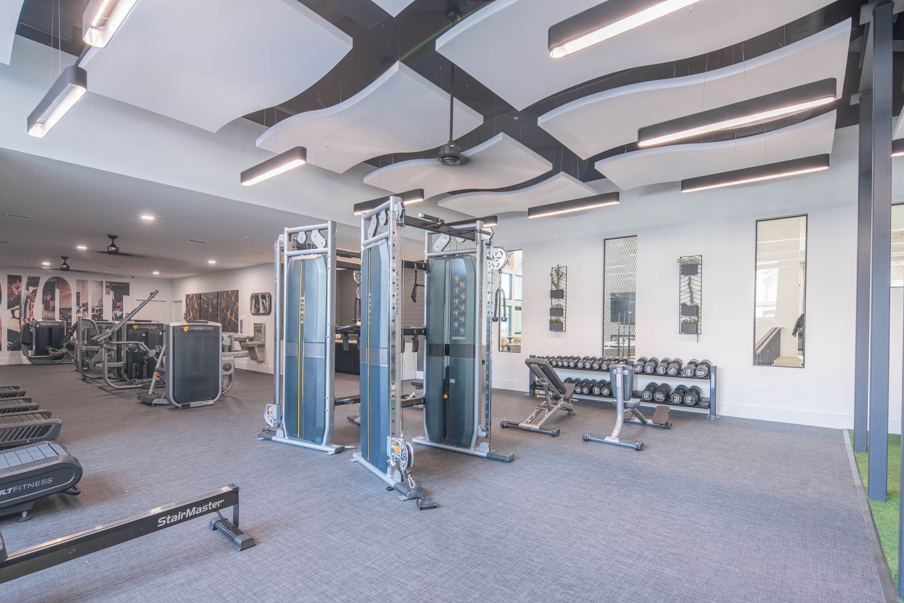 Et moderne fitnesscenter med løbebånd, styrkemaskiner og håndvægte.