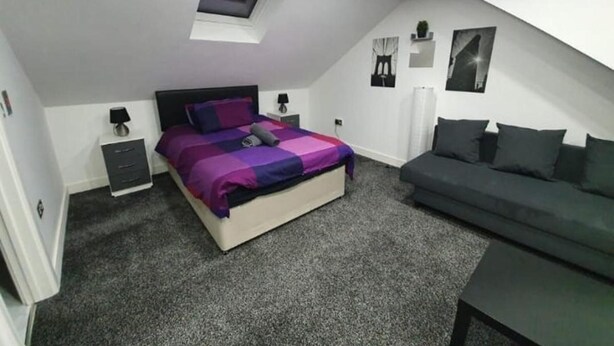 Une chambre à coucher avec un lit, un canapé, un bureau et une fenêtre.