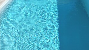 A rectangular swimming pool with clear blue water, surrounded by a light-colored tiled deck. - Cosy country B&B  (Comines-Warneton)