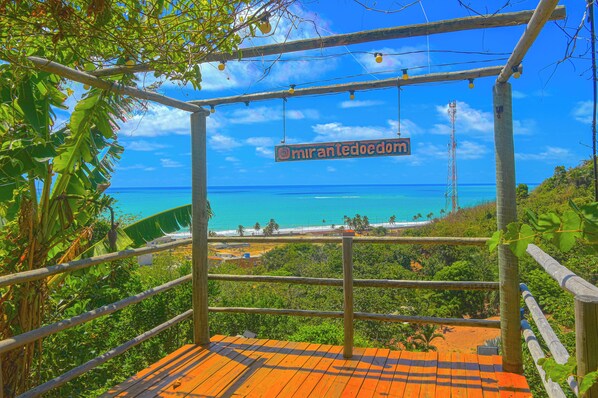 A wooden viewing platform with a sign reading "miranteedom" overlooking a beach and ocean. - Casa Edom - Max Rev (Maceió)