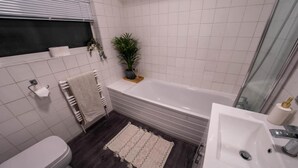 Ein Badezimmer mit Badewanne, Toilette und Waschbecken.