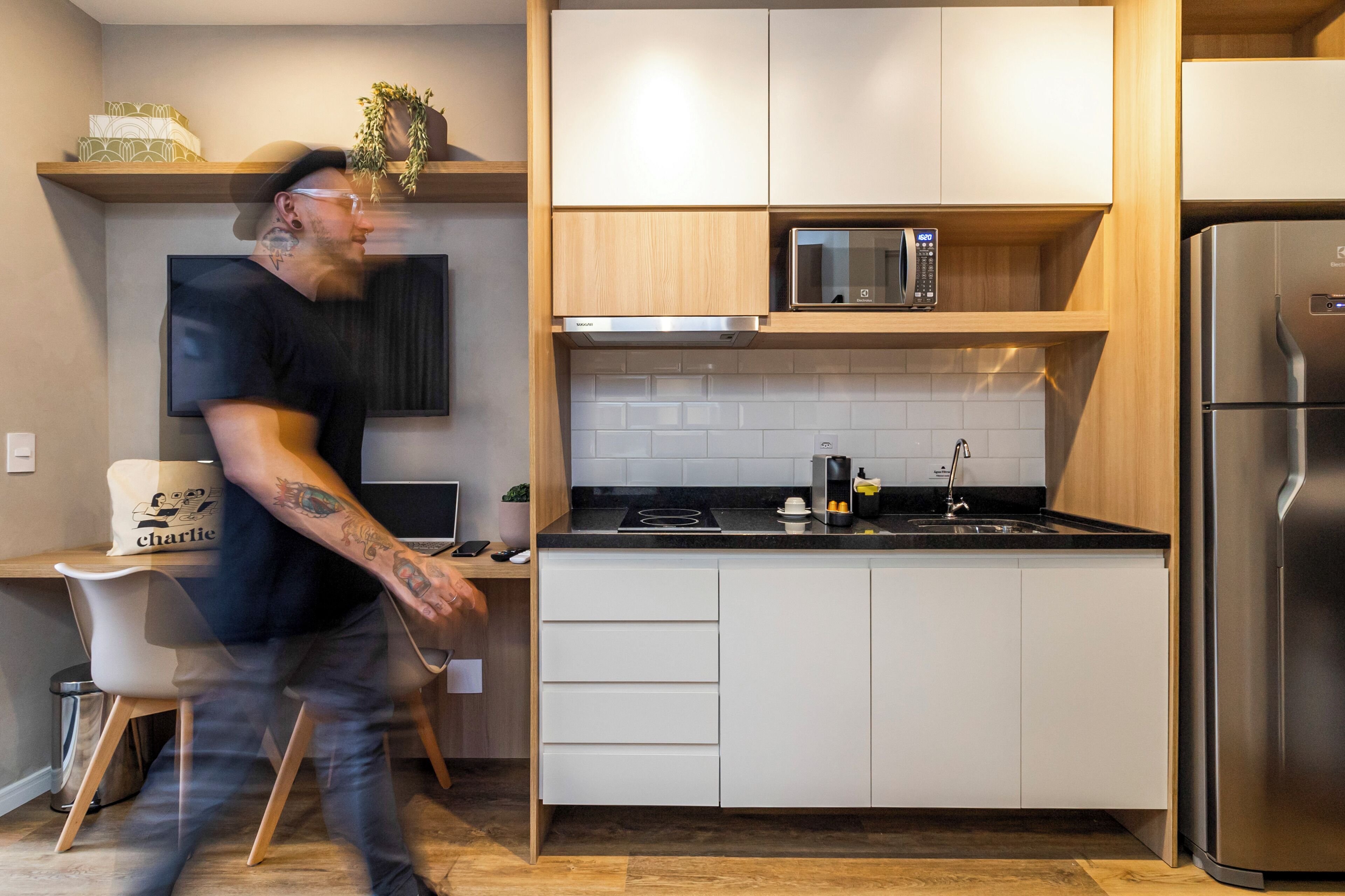 A modern kitchen with white cabinets, a stainless steel refrigerator, and a microwave.