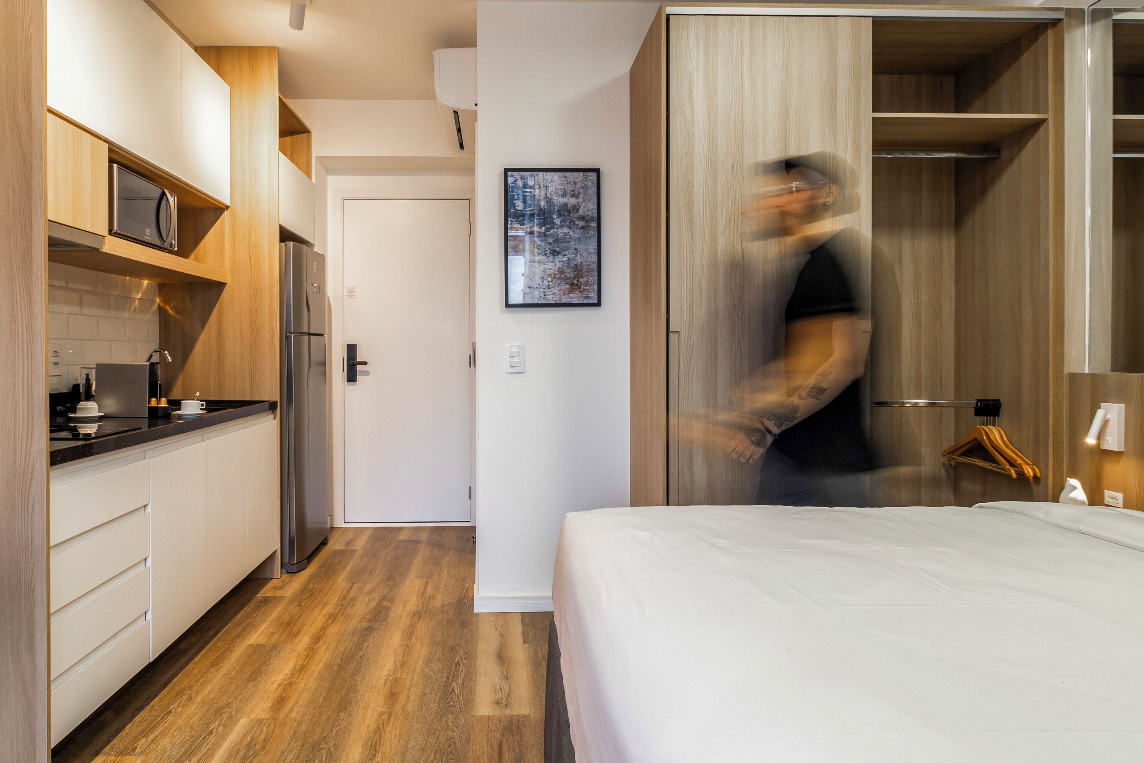 A modern kitchen with wooden cabinets, a refrigerator, and a microwave.