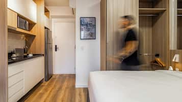 A modern kitchen with wooden cabinets, a refrigerator, and a microwave.