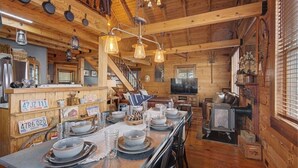 Een rustiek houten interieur met een eethoek, keuken en een trap.