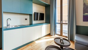 Une cuisine moderne équipée d’un téléviseur encastré, d’un évier et d’une fenêtre avec des rideaux.