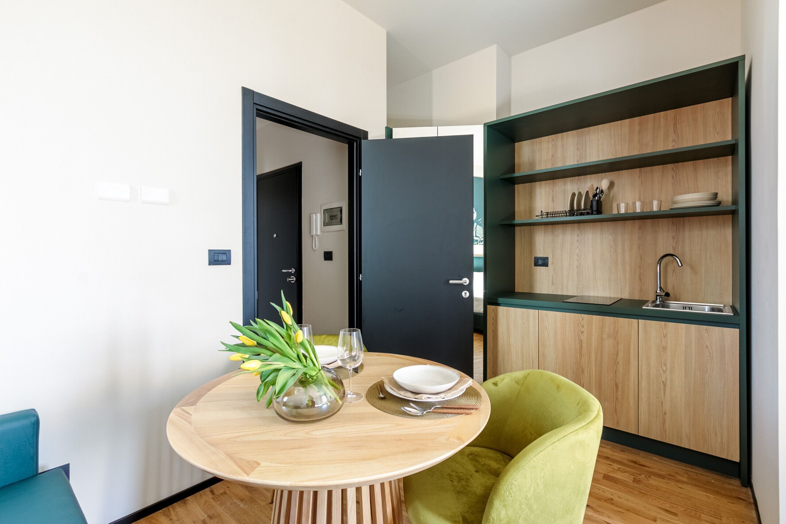 Eine moderne Küche mit einer Holz Arbeitsplatte, einem Spülbecken und einer eingebauten Ablage mit Geschirr.