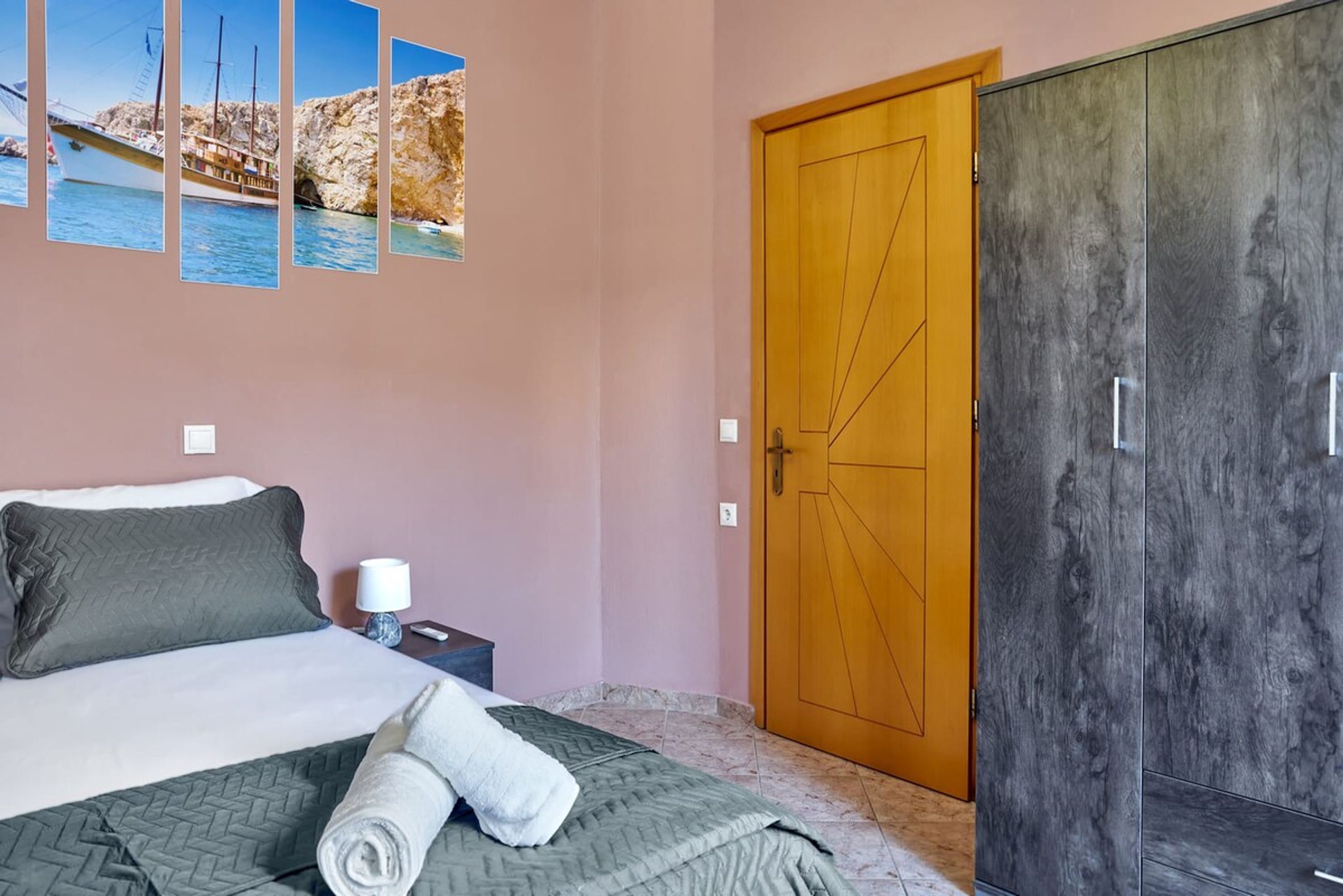 A bedroom with a bed, a wooden door, and a wardrobe.