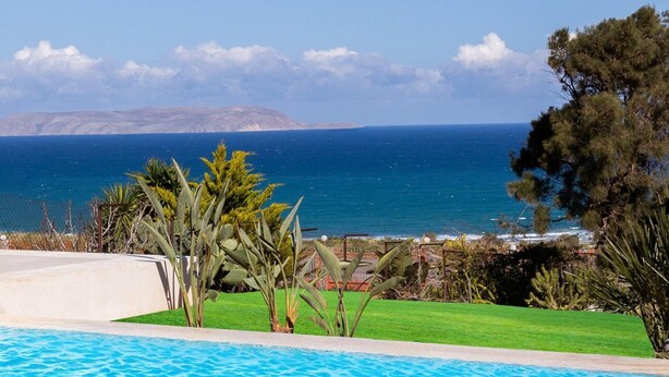 Una piscina con vistas al mar y a las montañas.