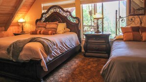 A bedroom with a large bed, two bedside tables with lamps, and a window with blinds. - Little Slice of Heaven (Wofford Heights)