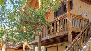 A wooden cabin with a balcony and a staircase leading to the upper level. - Little Slice of Heaven (Wofford Heights)