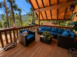 A wooden deck with a sofa and chairs, a telescope, and a plant. - Little Slice of Heaven (Wofford Heights)