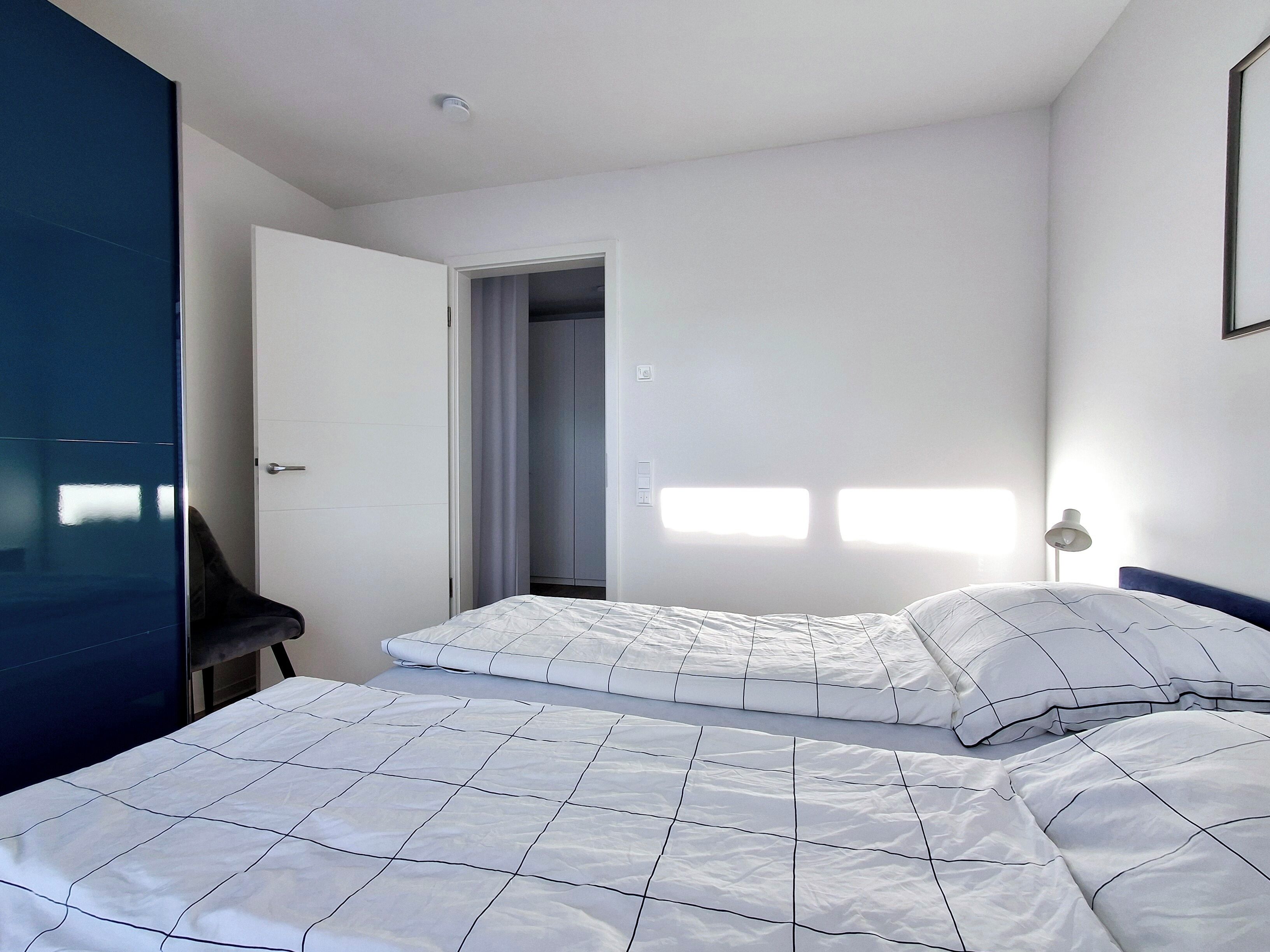 Une chambre à coucher avec un lit, une chaise et une armoire.