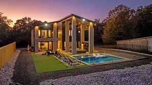 Une maison moderne à deux étages, dotée d’une piscine, d’un espace extérieur aménagé et d’un jardin bien entretenu.