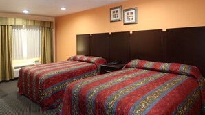 Una habitación de hotel con dos camas, un ventanal con cortinas y un televisor montado en la pared.