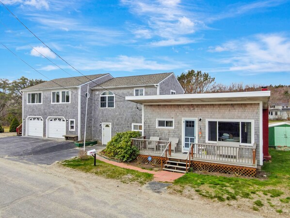 A two-story house with a garage, a front porch, and a small deck.
