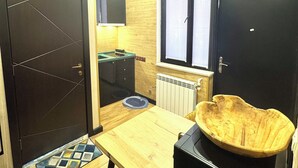 A compact kitchen with a wooden countertop, a black sink, and a large window.