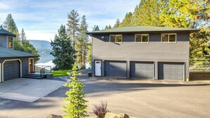 A two-story house with a garage, a driveway, and a small front yard with a tree and a rock. - Lake-View Apt w/ Furnished Deck in Hayden! (Hayden)