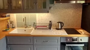 A compact kitchen with a sink, stove, and cabinets. - This mountain cocoon offers an idyllic setting for hiking enthusiasts. (Saint-Nizier-du-Moucherotte)