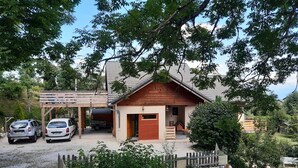 A small wooden cabin with a stone wall and a wooden fence in front. There are two cars parked outside. - This mountain cocoon offers an idyllic setting for hiking enthusiasts. (Saint-Nizier-du-Moucherotte)