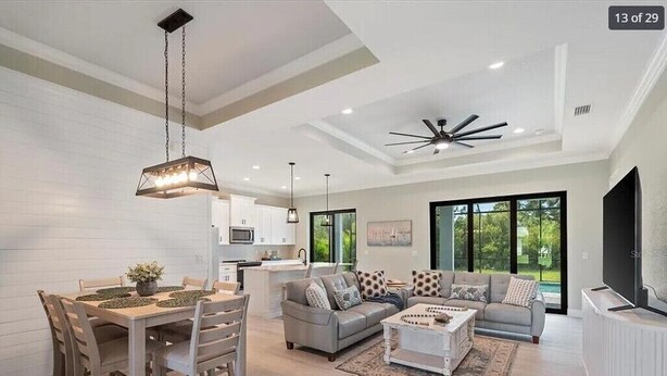 A modern living room with a dining area, a sofa set, and a TV. - Modern Retreat 3BR/2BA w/Pool in Rotonda West (Rotonda West)