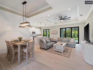 A modern living room with a dining area, a sofa set, and a TV. - Modern Retreat 3BR/2BA w/Pool in Rotonda West (Rotonda West)