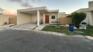 Une maison moderne à deux étages, dotée d’un patio couvert et d’un garage.