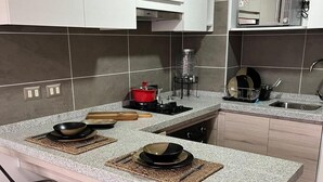 Una cocina moderna con una isla central, electrodomésticos de acero inoxidable y lavavajillas.