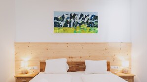 A double bed with white linens, two bedside tables with lamps, and a painting of mountains on the wall. - Apartments Haus Altenberger - Bergblick, Mountain view & Balcony (Zell am See)