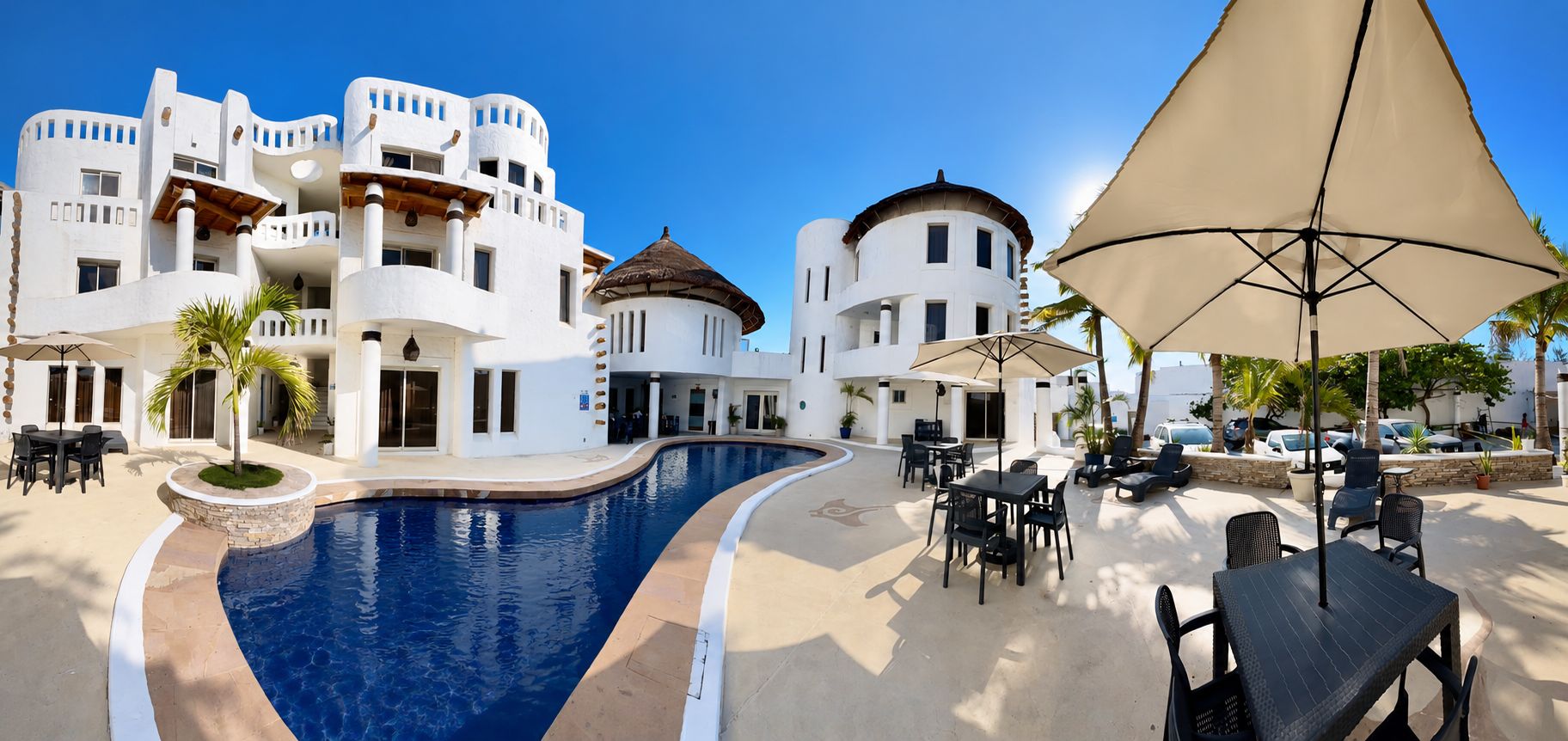 A poolside area with outdoor seating and a large umbrella.