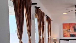 A hotel room with a large bed, a nightstand, and a painting on the wall.