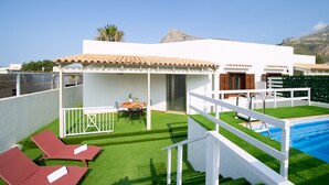 A modern villa with a pool, green artificial grass, and red lounge chairs. - Villa Lilibeth, A private villa with private swimming pool in San Vito Lo Capo (San Vito Lo Capo)