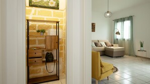 A modern living room with a sectional sofa, a yellow armchair, a coffee table, and a side table with a plant. - Villa Lilibeth, A private villa with private swimming pool in San Vito Lo Capo (San Vito Lo Capo)