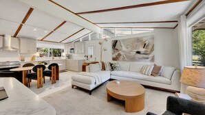 A modern living room with a sofa, coffee table, and dining area.