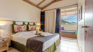 Un dormitorio con cama, mesitas de noche, una ventana con cortinas y vistas al exterior.