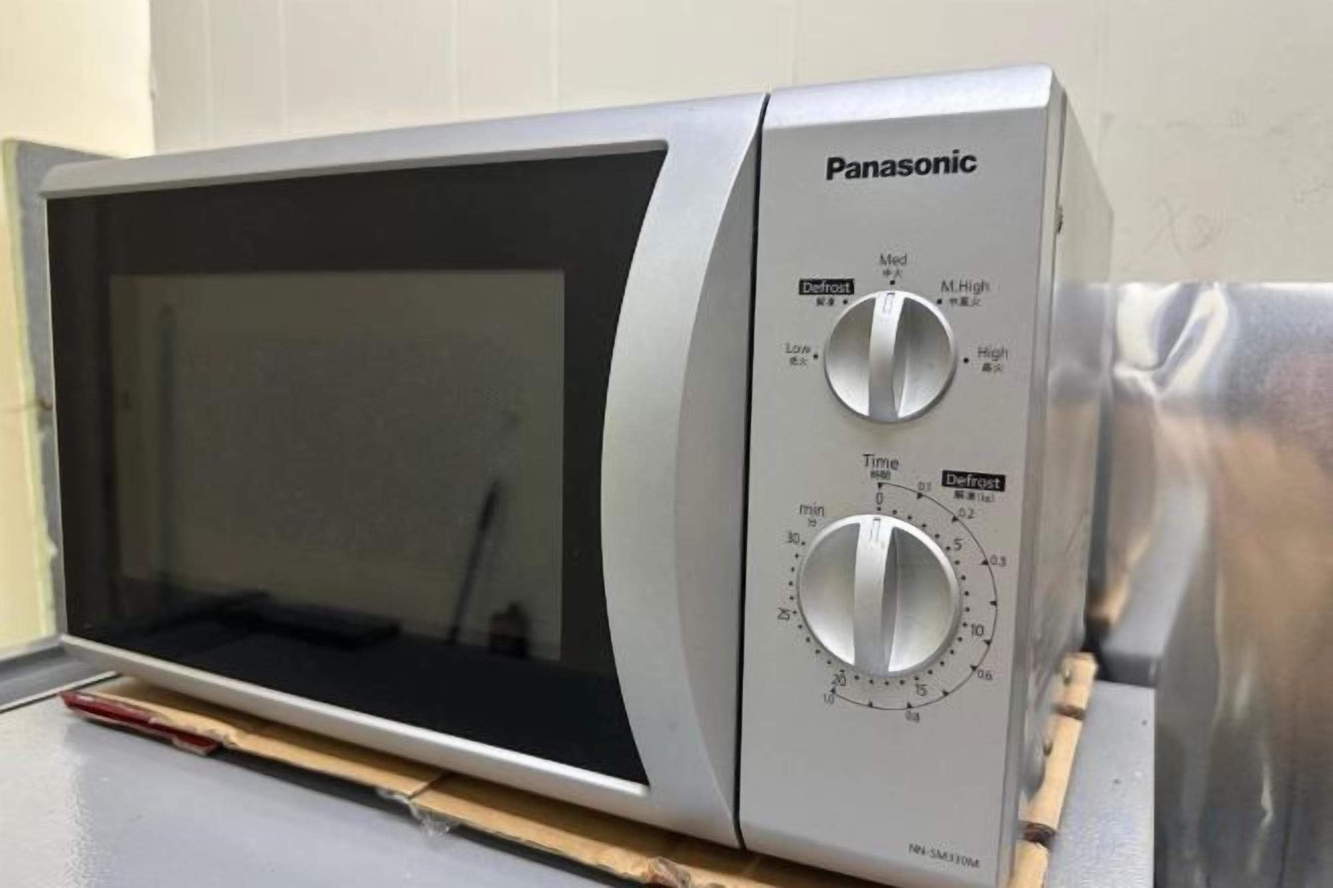 A Panasonic microwave oven with two dials, one for power and one for time settings.