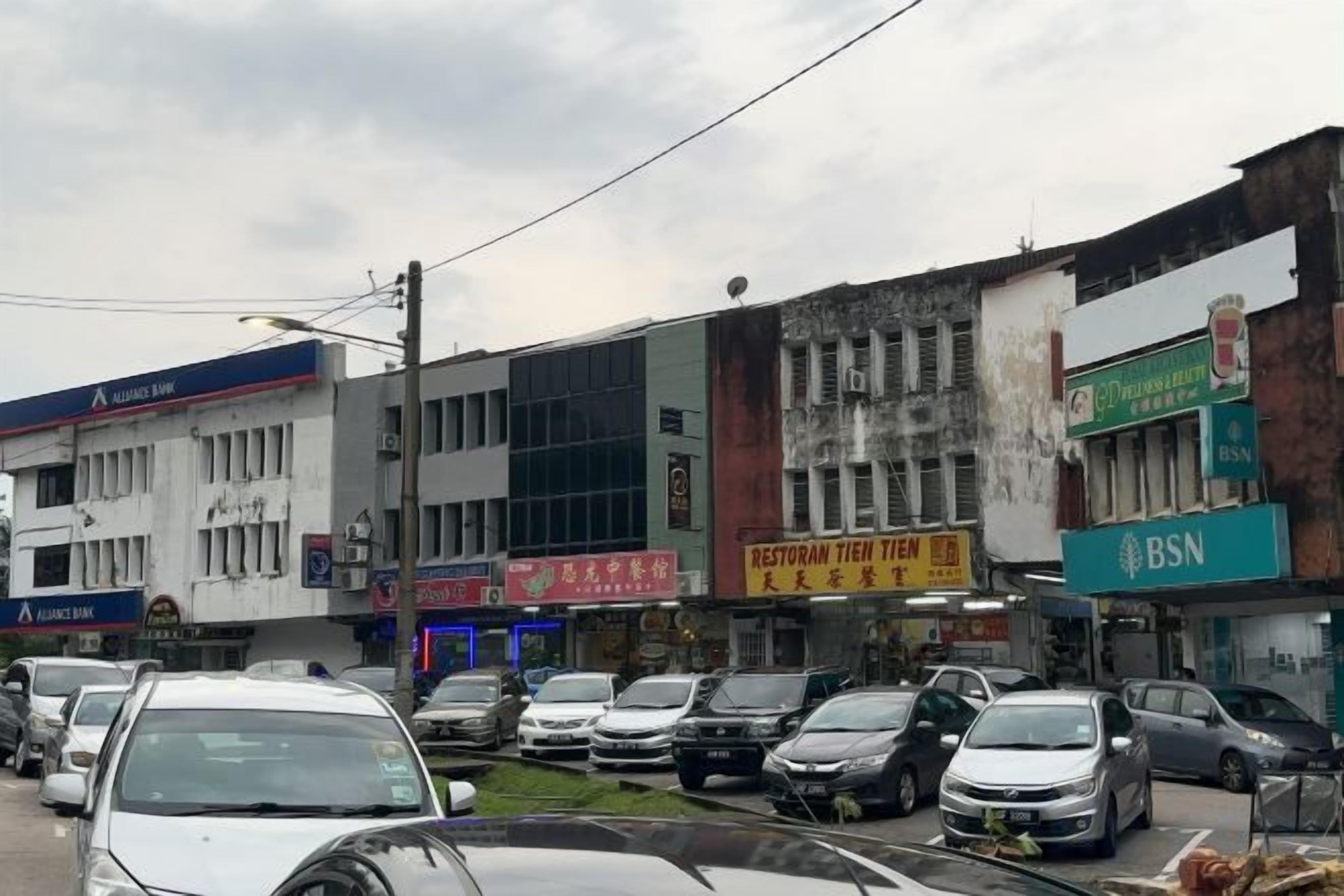 A street with multiple commercial buildings, including a bank and a restaurant.