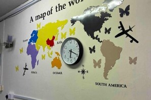 A wall with a world map and a clock.