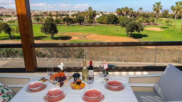 A table set for a meal with a view of a golf course.