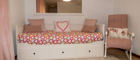 Une chambre à coucher avec un lit, une chaise et un miroir au mur.