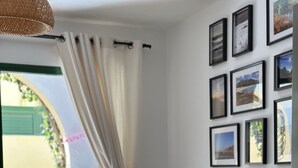 A modern living room with a dark grey sofa, a coffee table, and a dining area visible through an open door. - Casa Garza – Castillo Mar 100m from the oceanfront (Caleta de Fuste)