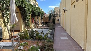 A narrow alley with tiled flooring, potted plants, and outdoor seating. - Casa Garza – Castillo Mar 100m from the oceanfront (Caleta de Fuste)