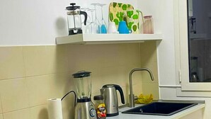 Une cuisine équipée d’une cuisinière, d’un four, d’un évier et de divers ustensiles de cuisine disposés sur le plan de travail.
