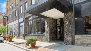 A building with a stone facade, large windows, and a covered entrance.