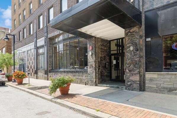 A building with a stone facade, large windows, and a covered entrance.