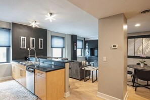A modern kitchen with a central island, built-in appliances, and a dining area with a table and chairs.